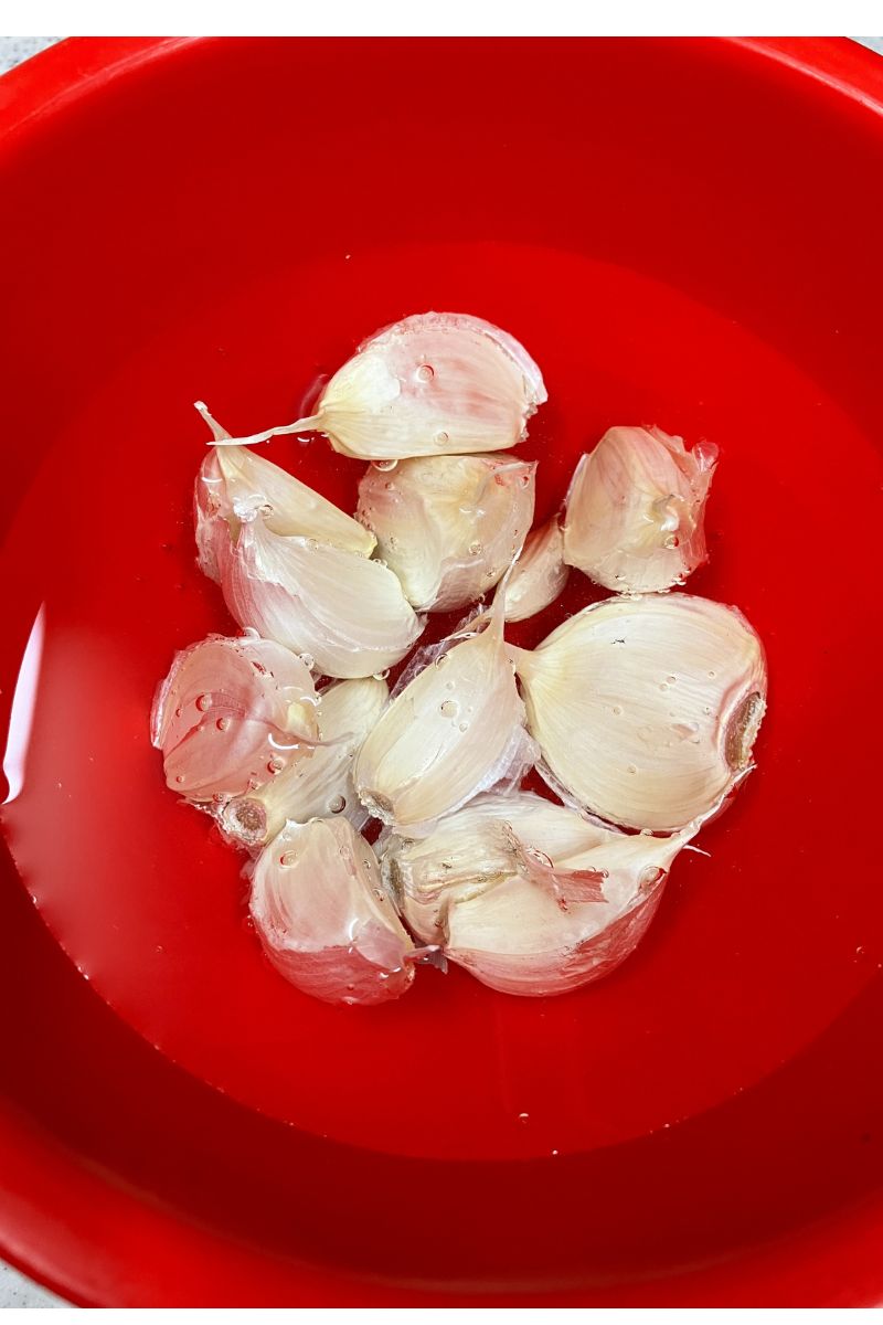 薄皮をむくために水につけたにんにく